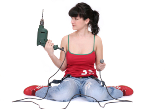 woman sitting with a drill on the floor. isolated